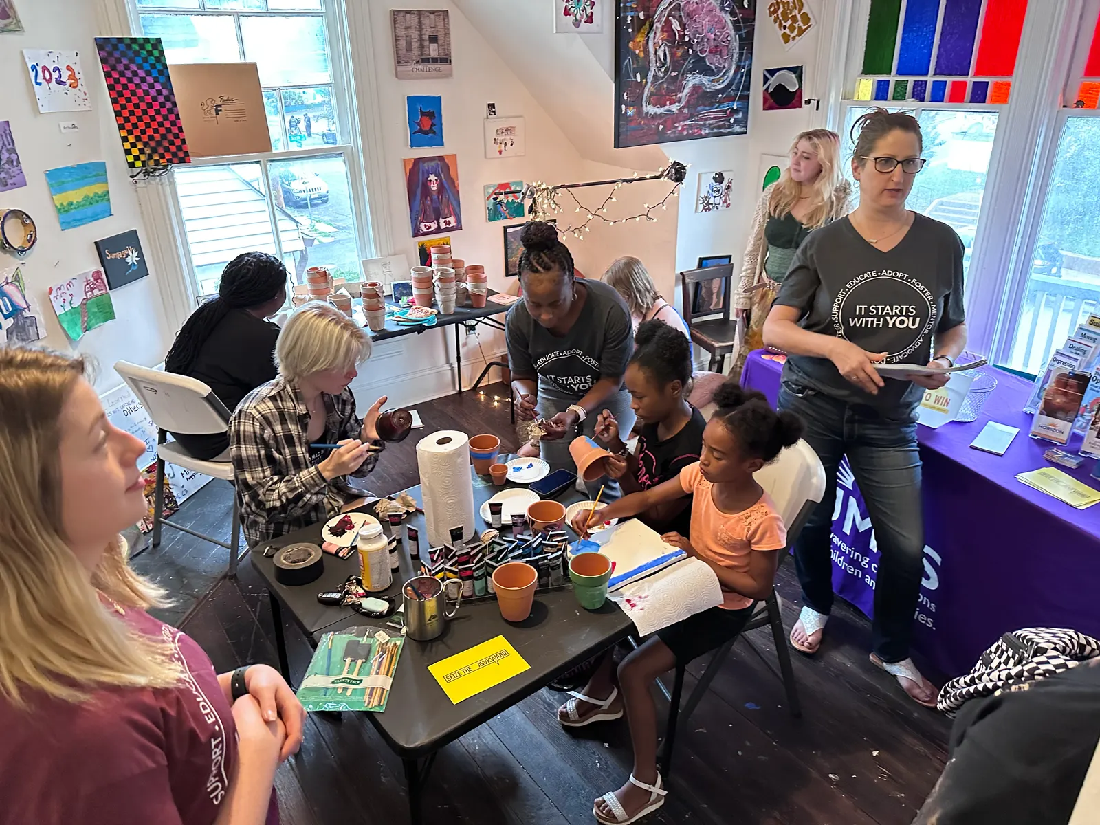 Neighbors of all ages make art together around a table at The Clarity House