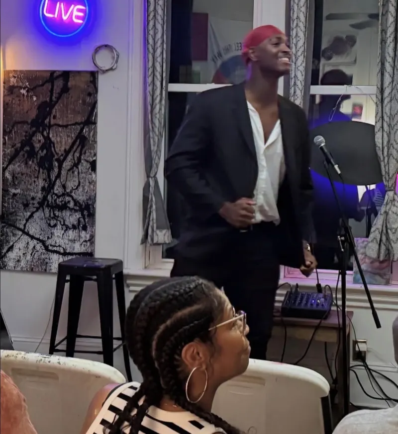 A performer at the mic beneath the neon LIVE sign